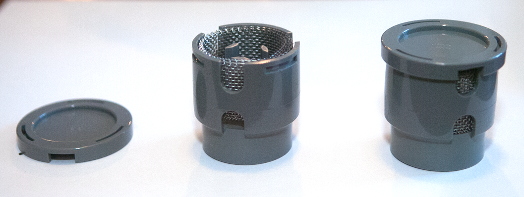 Two grey plastic parts, one holding a metal mesh. The parts snap together.